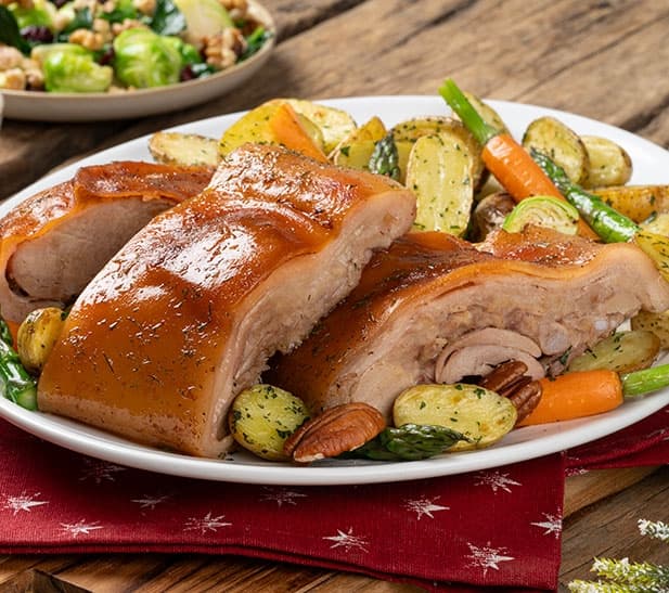 Lechón navideño con salsa de tamarindo y vegetales al horno